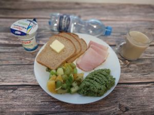 Zdjęcie przedstawia Dietę z ograniczeniem łatwo przyswajalnych węglowodanów:  Chleb Graham Masło extra  Sałatka owocowa  Szynka krucha z pieca wieprzowa, parzona Kawa zbożowa z mlekiem Jogurt naturalny Woda mineralna  Pasta z groszku zielonego